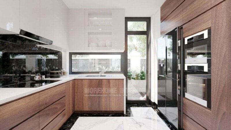 Là một trong những xu hướng thiết kế nội thất nổi bật trong những năm tới, thiết kế phòng bếp hiện đại tôn lên vẻ đẹp mộc mạc nhưng không kém phần sang trọng của gỗ điển hình là gỗ óc chó veneer . Loại gỗ rất được ưa chuộng trong các siêu xe bởi vẻ đẹp ấn tượng từ vân, màu gỗ. Như trong ý tưởng thiết kế phòng bếp tại biệt thự Vinhomes Imperia Hải Phòng, sự hài hòa tôn lên nét đẹp giữa truyền thống và hiện đại, tủ bếp dưới gỗ óc chó và tủ bếp trên acrylic trắng bóng. Mẫu tủ bếp biệt thự acrylic